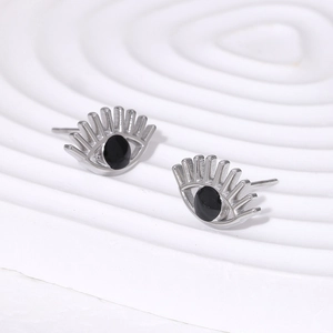 Macro shot of silver evil eye stud earrings with black pupil inlay on artistic base
