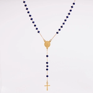 Detail of gold rosary necklace featuring deep blue beads, holy medal, and a cross pendant