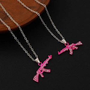 Hip hop style silver necklaces with pink rhinestone AK-47 rifle pendants on black background