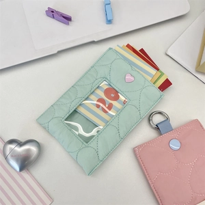 Close-up of quilted heart-shaped card holders in mint green and soft pink fabric