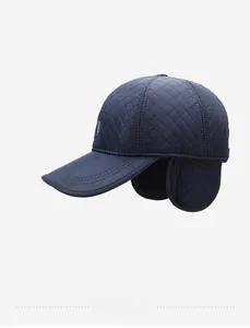 Detail of dark blue quilted baseball cap featuring fold-down ear flaps for winter warmth