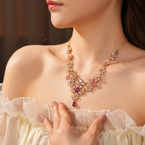 Close-up of vintage floral necklace with purple crystal pendant worn by a model