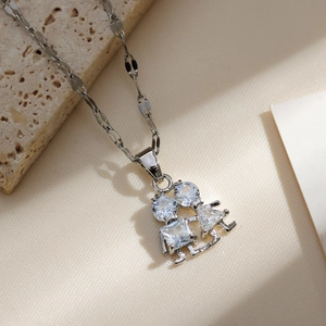 Macro shot of silver boy and girl pendant with sparkling zircon stones on a link chain