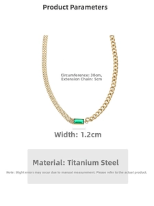 Macro detail of emerald gemstone pendant with asymmetric Cuban chain and gold plating