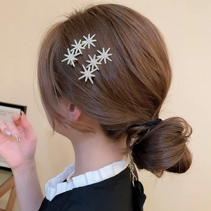 Detail of star-shaped rhinestone hair clip worn on elegant brunette updo hairstyle