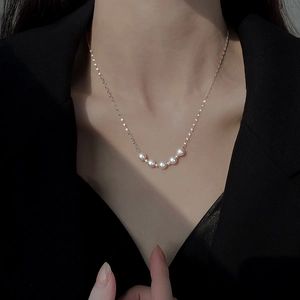 Elegant five-pearl titanium steel necklace for women on a model with a black blazer