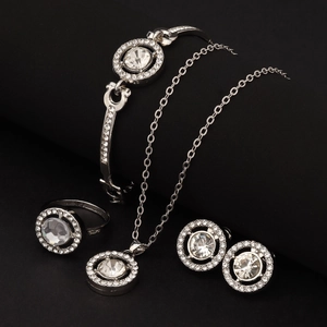 Detailed view of silver jewelry set featuring sparkling round zircon stones on black background