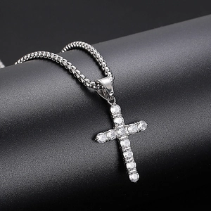 Macro shot of silver hip hop cross pendant with pave-set cubic zirconia on a box chain