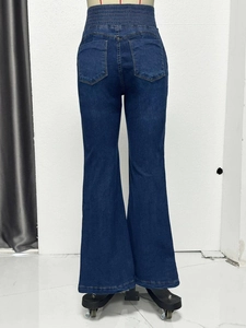 Detail view of high waist elastic waistband and back pockets on dark blue flared jeans