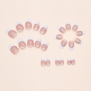 Macro shot of 24pcs French press-on nails with silver bows and sparkling rhinestones