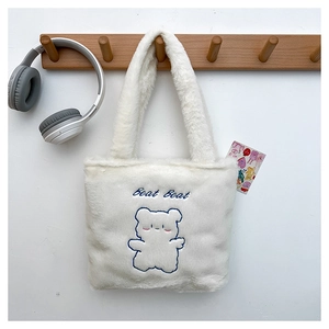 Détail du sac cabas en peluche blanche avec broderie ours bleu et texte Beat Beat