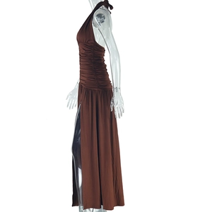 Detail view of the deep brown halter neck dress showing side slit and pleated fabric texture