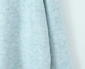Close-up of soft light blue mohair knit fabric showing detailed fluffy texture and weave