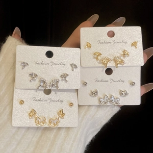 Détail des boucles d'oreilles poney et feuilles de ginkgo dorées avec zircons brillants