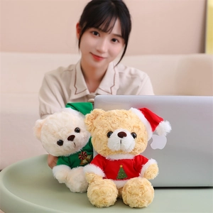 Detail of Christmas teddy bears in green and red festive outfits on a cozy desk
