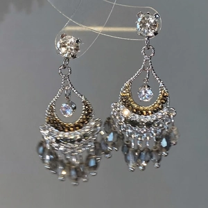 Détail de boucles d'oreilles vintage en argent avec cristaux et pompons métalliques