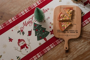Close-up of beige Christmas table runner with red plaid patterns and snowman embroidery