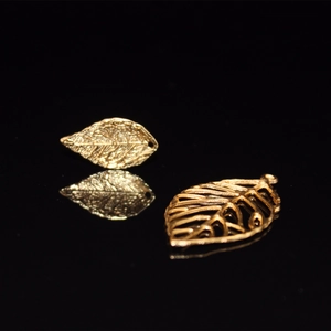 Golden minimalist leaf-shaped metal jewelry components with solid and hollow designs