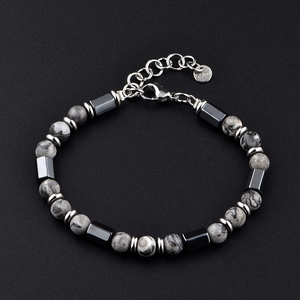 Détail d'un bracelet en perles d'hématite et œil de tigre sur fond noir texturé