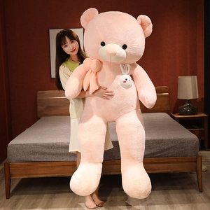 Detail of giant pink plush teddy bear with silk bow tie and rabbit patch in a bedroom