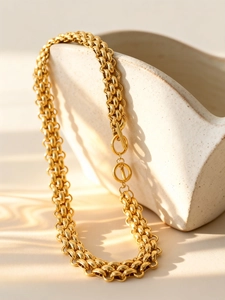 Detailed close-up of golden chunky chain necklace with a unique double-ring toggle clasp