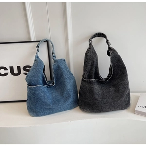 Macro detail of blue and charcoal washed denim tote bags with metallic adjustable hardware