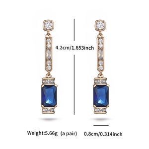 Detail of gold-plated geometric earrings with blue gemstones and size measurements