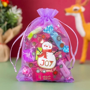 Purple organza Christmas treat bag with festive snowman tag and colorful candies inside