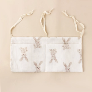 Detail of baby crib storage bag showing soft cotton fabric and rabbit pattern print