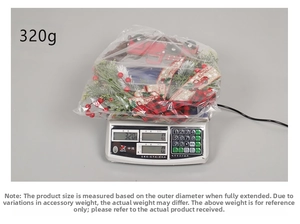 Christmas wreath with red truck, pine needles and bow being weighed on a scale