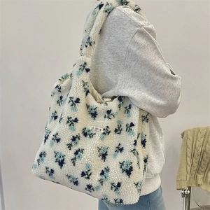 Detail of floral plush tote bag with lamb wool texture and embroidered brand label