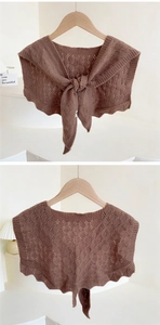 Detail of brown knitted shawl showing intricate diamond hollow pattern and wavy edges