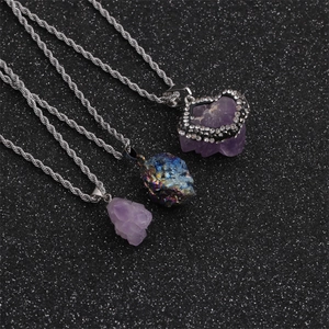 Three amethyst and iridescent stone necklaces with silver twist chains on dark background