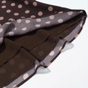 Detailansicht des braunen Polka-Dot-Chiffonrock-Saums mit doppellagigen Rüschenkanten