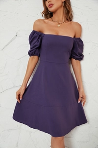 Close-up of deep purple square neck dress with puff sleeves against a stone wall