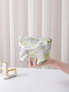 Floral makeup bag with jacquard fabric and petal-shaped zipper shown in a hand