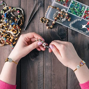 DIY jewelry kit with colorful beads and metal tools on a dark wood background