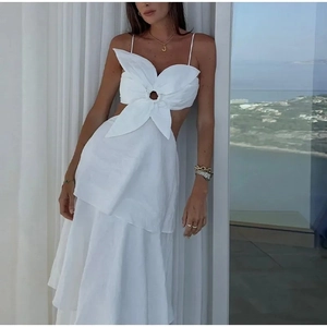 Détail d'une robe longue blanche sans manches avec un grand nœud et une taille découpée