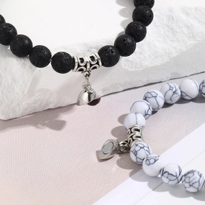 Macro view of couple's magnetic heart bracelets with black lava and white stone beads