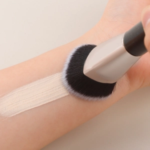 Detailed shot of soft heart-shaped brush applying BB cream foundation on skin