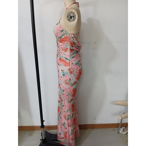 Detail view of side ruching and vibrant floral print on an open-back midi dress