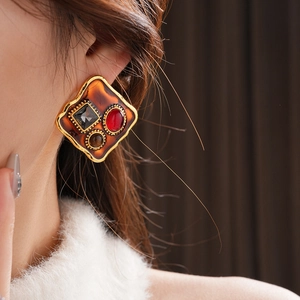 Gros plan sur la boucle d'oreille carrée vintage avec texture ambre et gemmes colorées