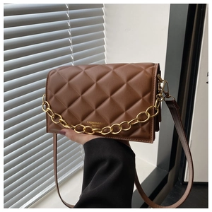 Close-up of brown quilted leather crossbody bag with decorative gold chain and logo detail