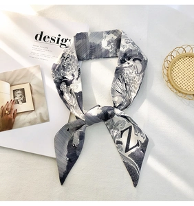 Detail of a black and white Twilly silk scarf with letter Z and animal motifs