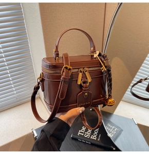Close-up of vintage brown box bag with gold-tone hardware and signature key charm