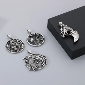 Ensemble détaillé de quatre pendentifs dragons en acier inoxydable de style vintage