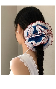 Blue and white lace scrunchie with red stitching detail shown on a high ponytail
