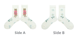 Detail of white cotton socks featuring cute cartoon cat and blue daisy jacquard patterns