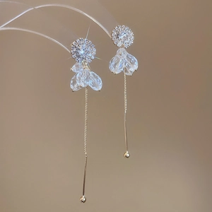 Detailed view of gold tassel earrings with micro-set zircons and faceted crystal drops