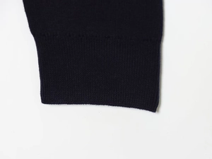 Detail shot of the ribbed knit cuffs on a navy blue contrast stitch polo shirt